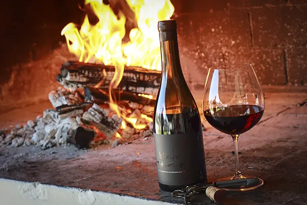 Red wine on display infront of a burning log fire